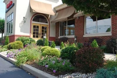 The Manor Inn's entrance awning and flower beds at the front of the building