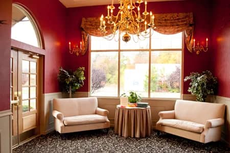 A wedding reception in the Manor Inn banquet room, tables set under a chandelier